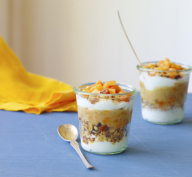 Glass jar with layered yoghurt, gluten-free cereal and papaya