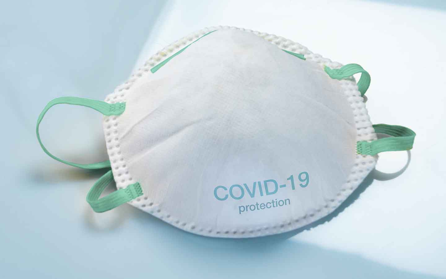 Face mask to protect against viral infections with COVID-19 protection printed on the bottom.