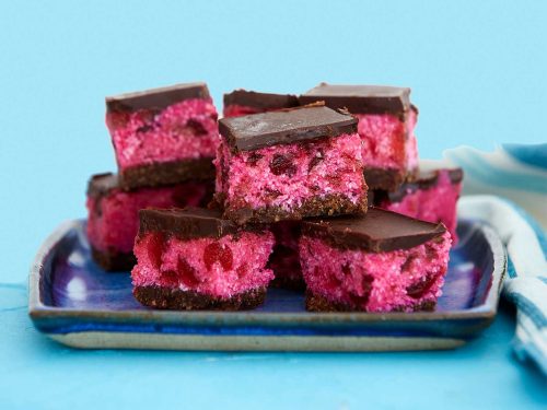 Gluten- and dairy-free cherry ripe slice cut into squared and arranged on a square blue plate.