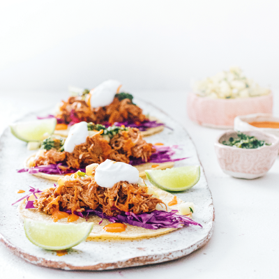 A platter of vegan tacos topped with slow cooker smoky pulled 'pork'.