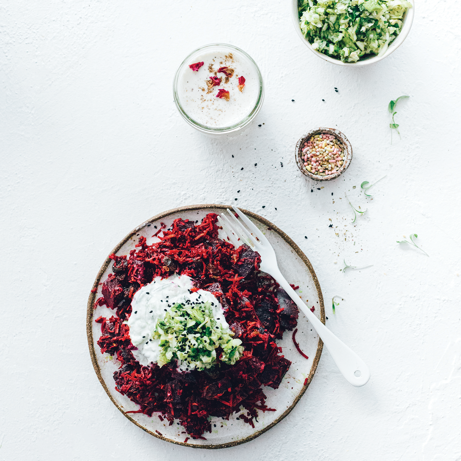 A large plate of slow cooked spiced beetroot topped with coconut yoghurt. Shot overhead lookind down.
