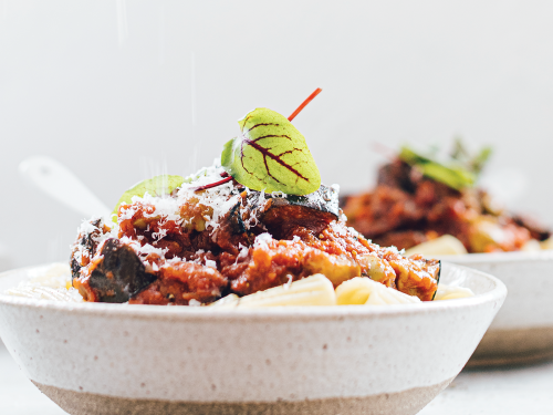 Two bowls of gluten-free pasta topped with thick & saucy vegetable bolognaise.