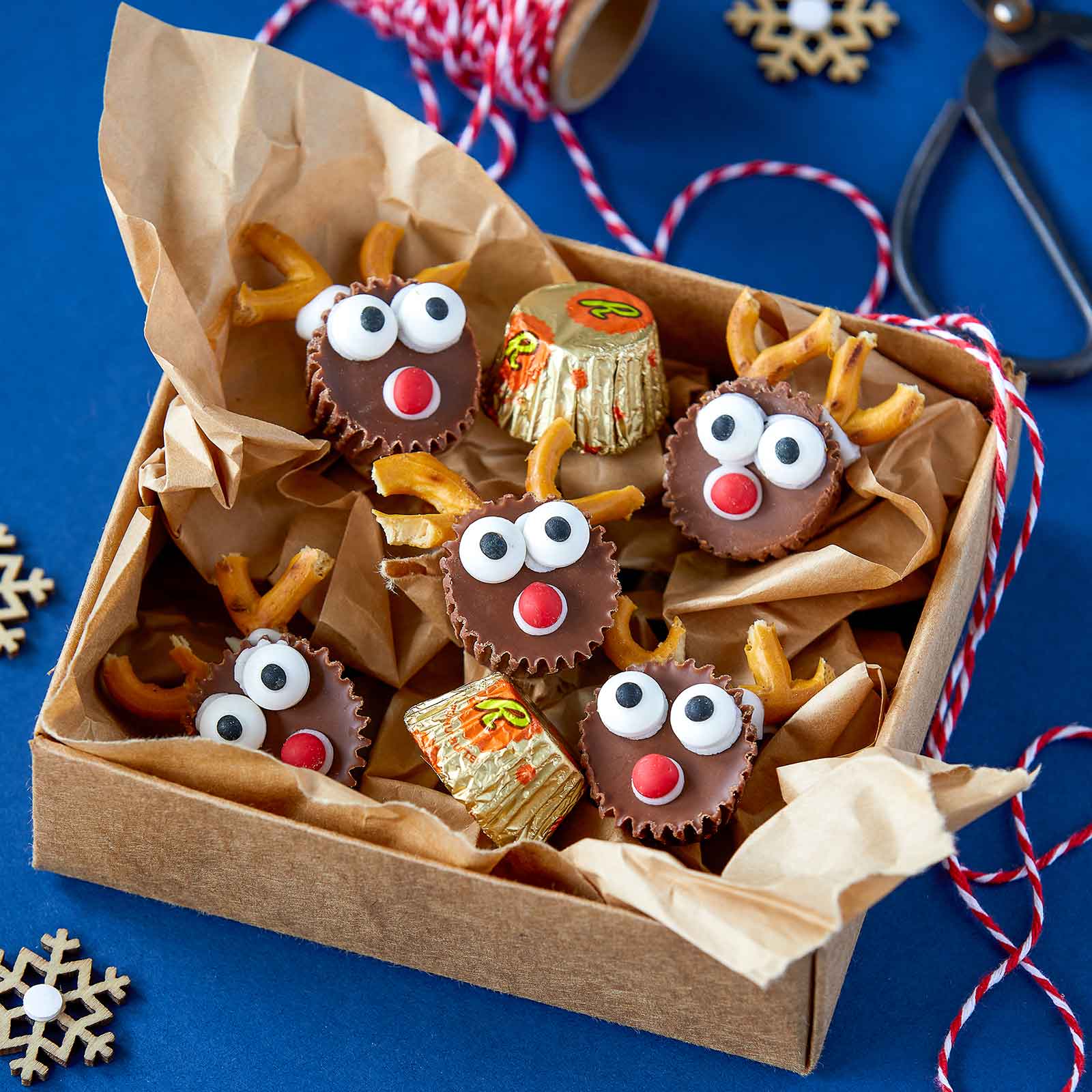 Gluten-Free Peanut Butter Reindeer arranged in a gold box with red and white twine ready for Christmas gifting.