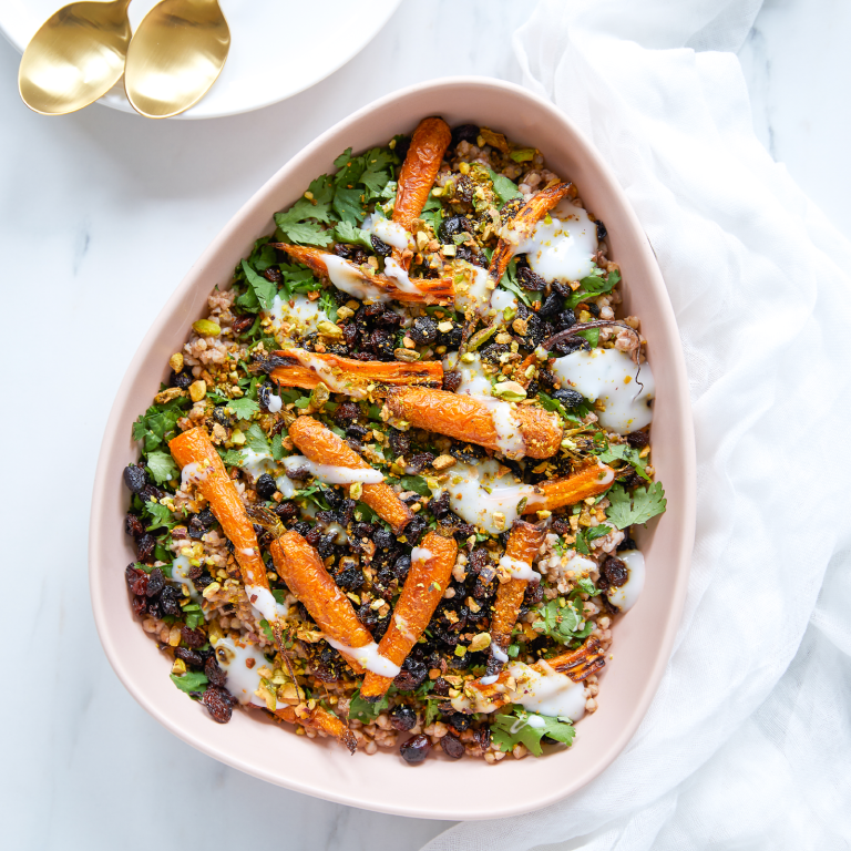 Gluten-Free-Life-Roasted-Baby-Carrots-and-Buckwheat-Salad-in-a-large-ceramic-pink-dish. The salad it topped with pistachios and drizzled with coconut yoghurt.